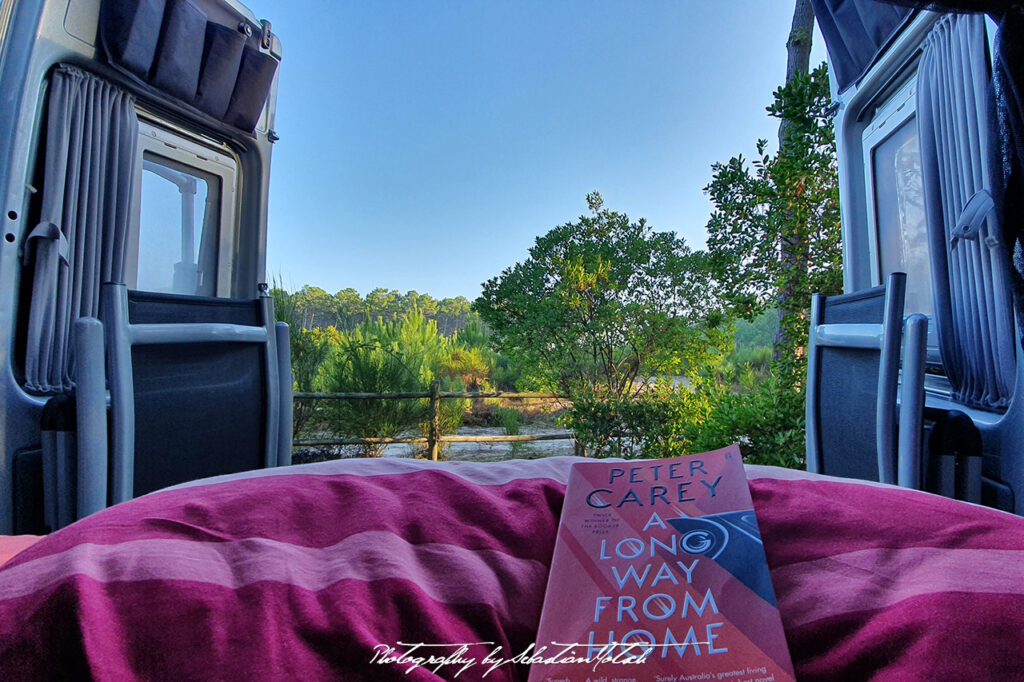 Reading a book in bed with the doors open to nature by Sebastian Motsch